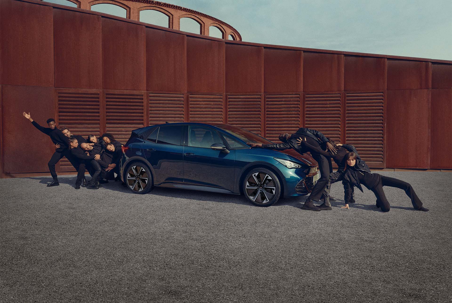 Persones posant amb un CUPRA Born de color Blau Aurora