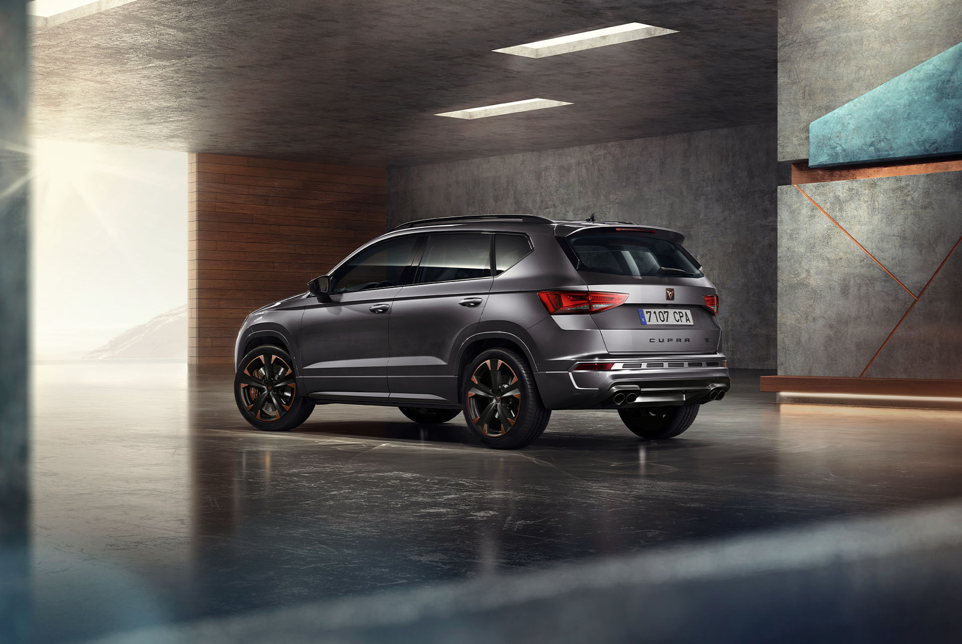 Un CUPRA Ateca SUV gris exposat sobre un fons blanc. El vehicle presenta una graella frontal imponent, fars LED i llandes d’aliatge amb detalls en coure, ressaltant el seu disseny esportiu.