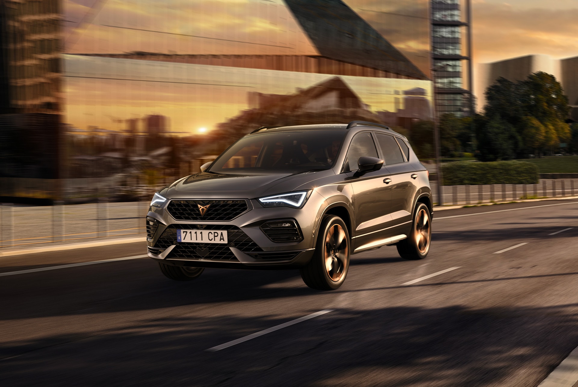 Un CUPRA Ateca SUV gris exposat sobre un fons blanc. El vehicle presenta una graella frontal imponent, fars LED i llandes d’aliatge amb detalls en coure, ressaltant el seu disseny esportiu.