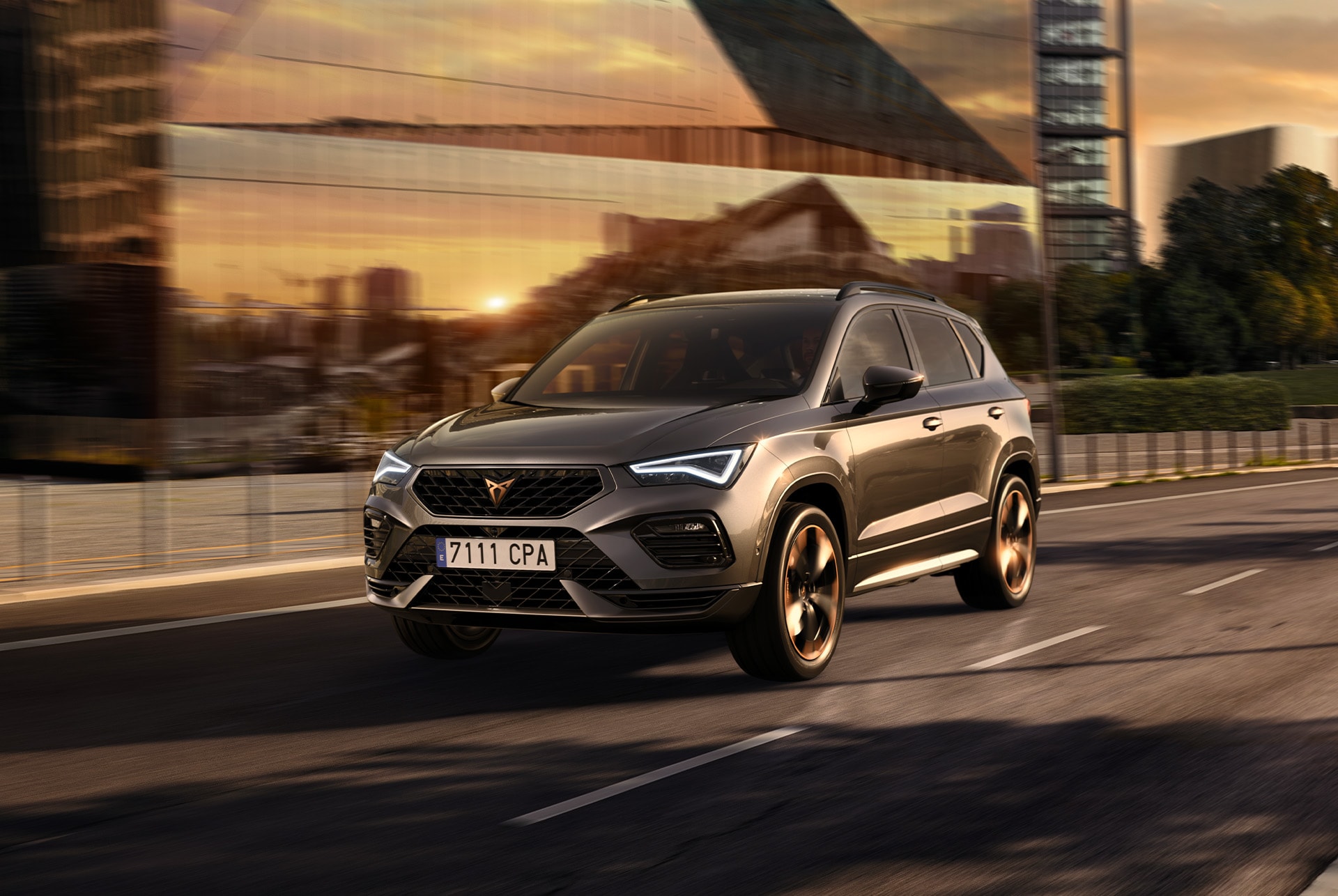 El CUPRA Ateca SUV circulant per una carretera urbana al capvespre. L'SUV està disponible amb motors de 150 CV i 190 CV amb tracció a les quatre rodes, oferint menys emissions i un menor consum de combustible.