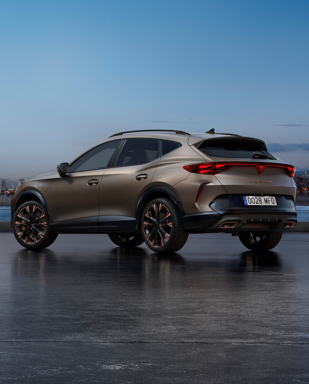 El nou SUV Crossover Cupra Formentor VZ 2025 bronze century mat aparcat en un passeig marítim durant el capvespre. El fons mostra un paisatge urbà amb gratacel i palmeres il·luminats per la llum del dia, que es va atenuant.