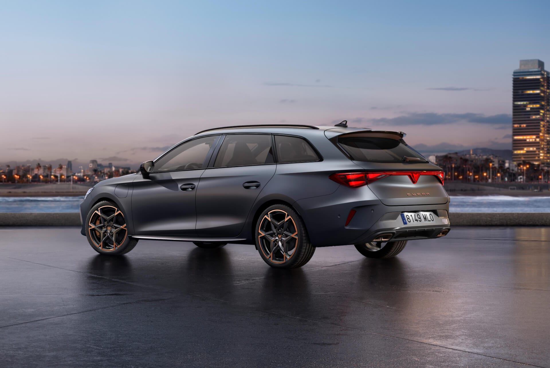 Vista posterior del nou model Cupra Leon Sportstourer 2025 en color gris brillant amb control dinàmic del xassís i llandes d'aliatge en negre i coure. Ciutat al fons al capvespre.