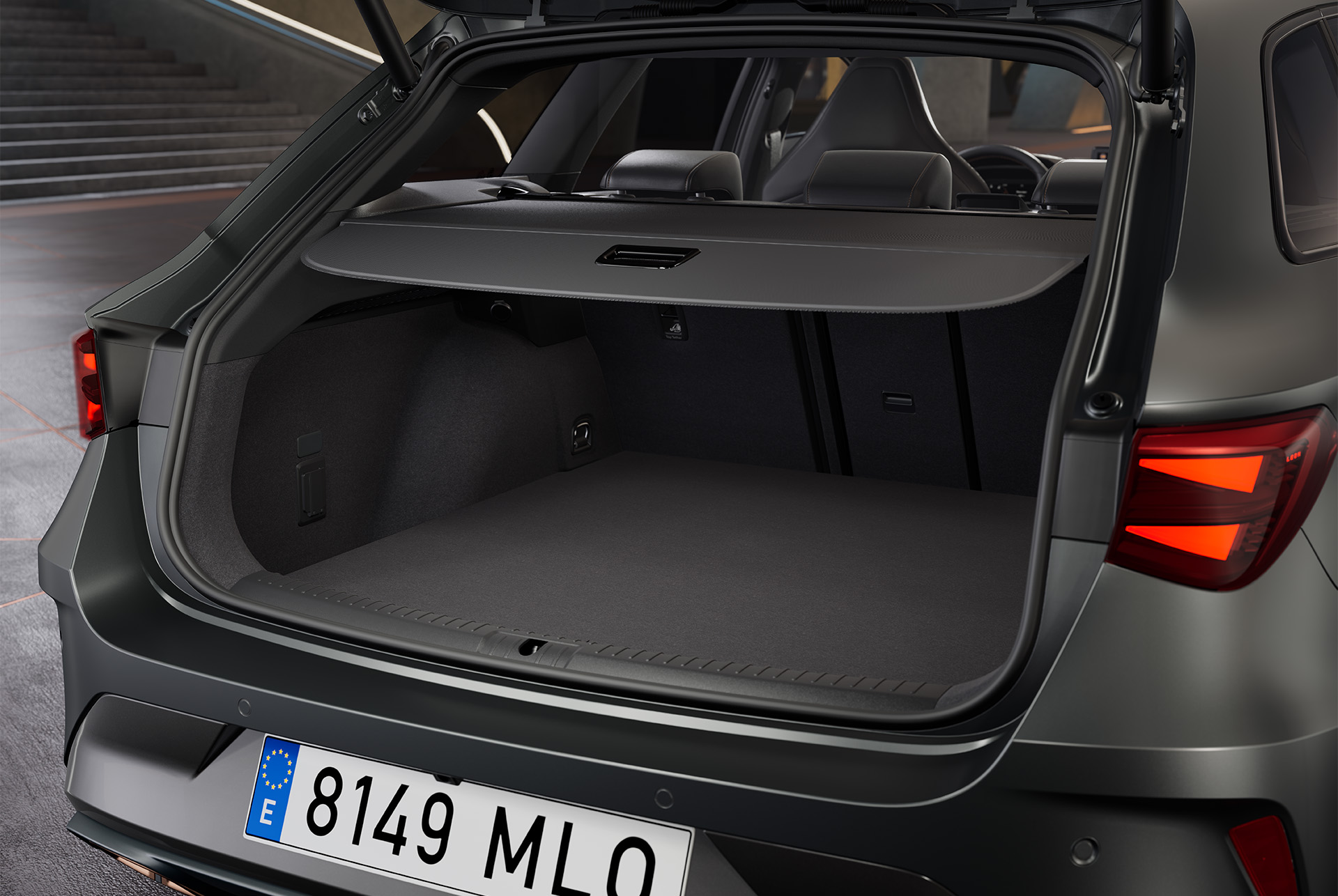 Maleter obert del nou CUPRA Leon Sportstourer 2025, vehicle híbrid  gris, que revela un espaiós maleter amb interior negre. Dins del maleter hi ha una bossa.