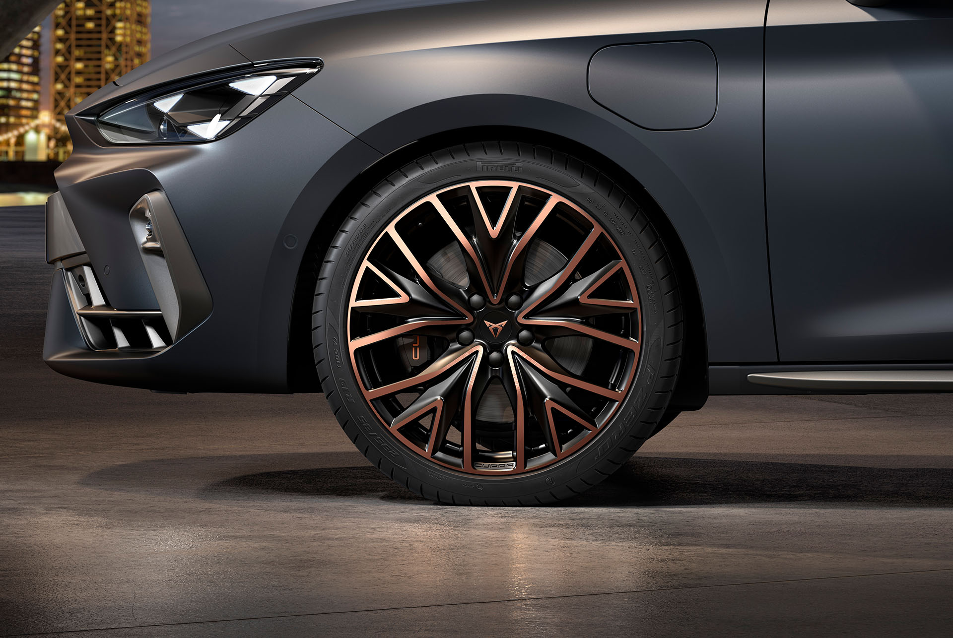 vista lateral davantera de les llandes forjades Mistral Cooper esquerres en coure i negre per al nou Cupra Leon Sportstourer 2025, pneumàtics, fars característics i carrosseria grisa. 
