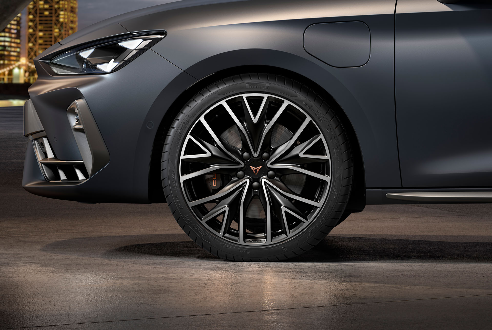 vista lateral davantera de les llandes d'aliatge mecanitzades esquerres en platejat i negre per al nou Cupra Leon Sportstourer 2025, pneumàtics, fars característics i carrosseria grisa. 