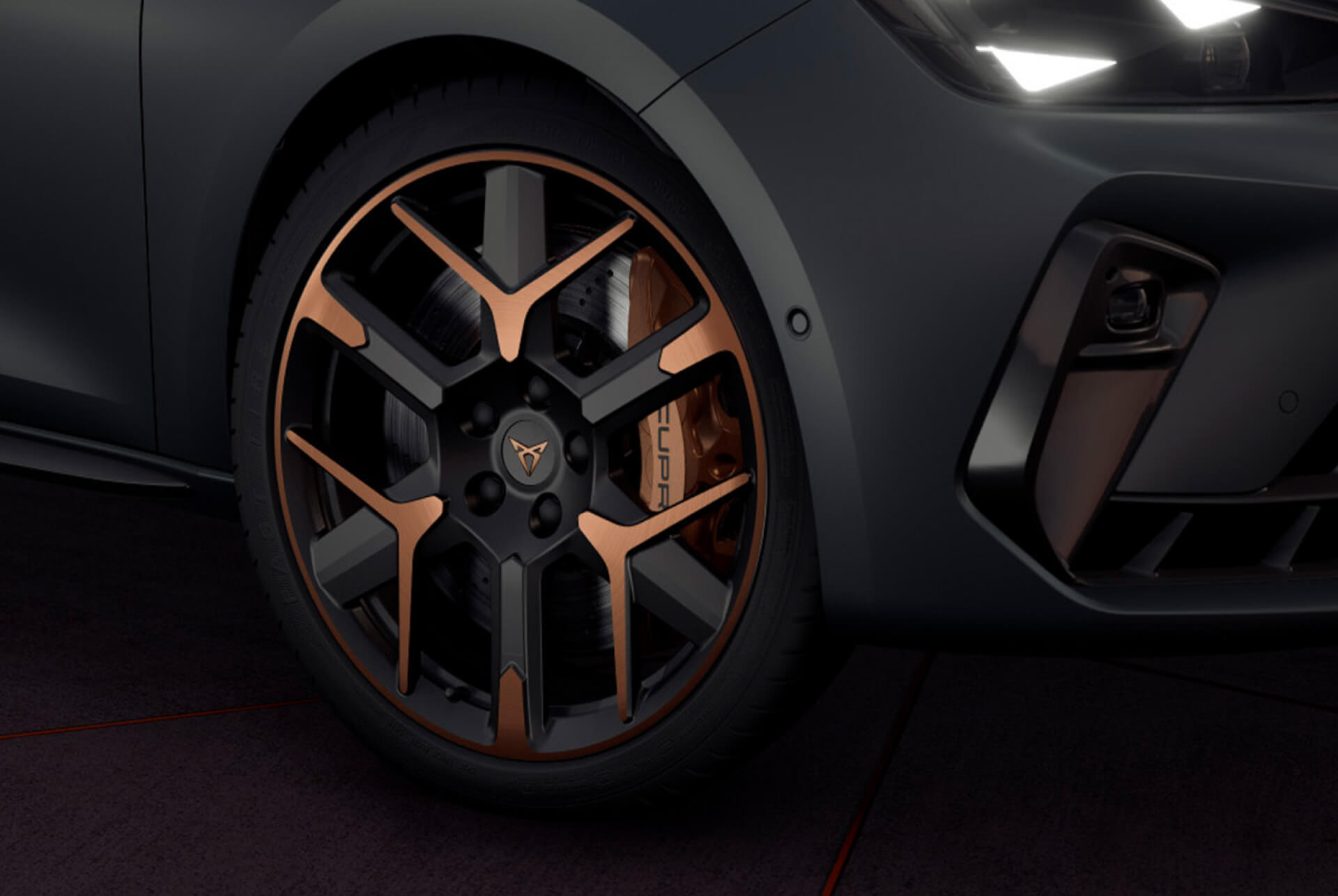 Nou Cupra Leon Sportstourer 2025, primer pla de les llandes amb acabat en coure i negres i els fars triangulars amb forma d'ull de Cupra, carrosseria gris Enceladus mat