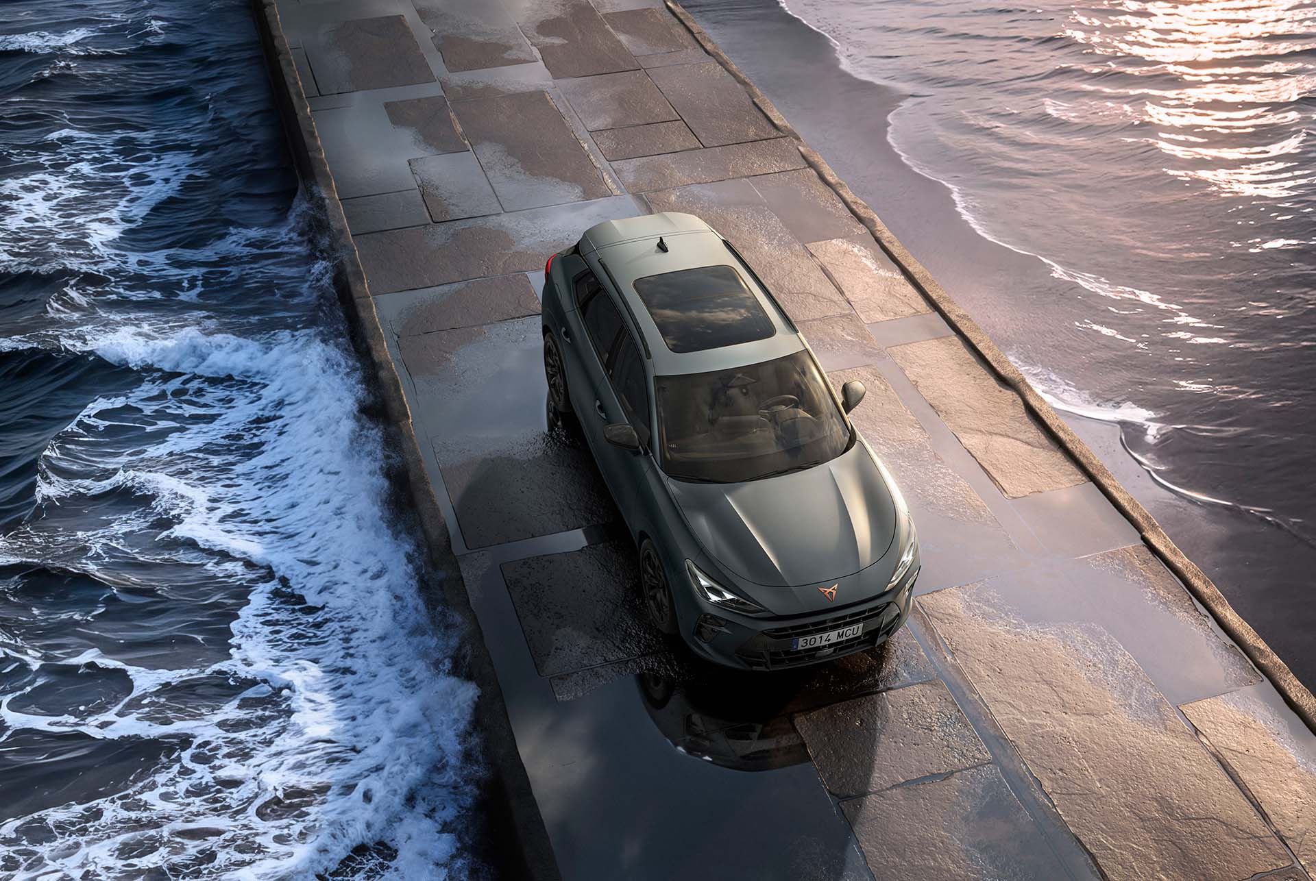 Nou model de SUV híbrid Cupra Terramar 2025, amb sostre panoràmic, disseny elegant i modernes llandes d'aliatge, vista d'ocell sobre un paviment mullat al costat de la mar.
