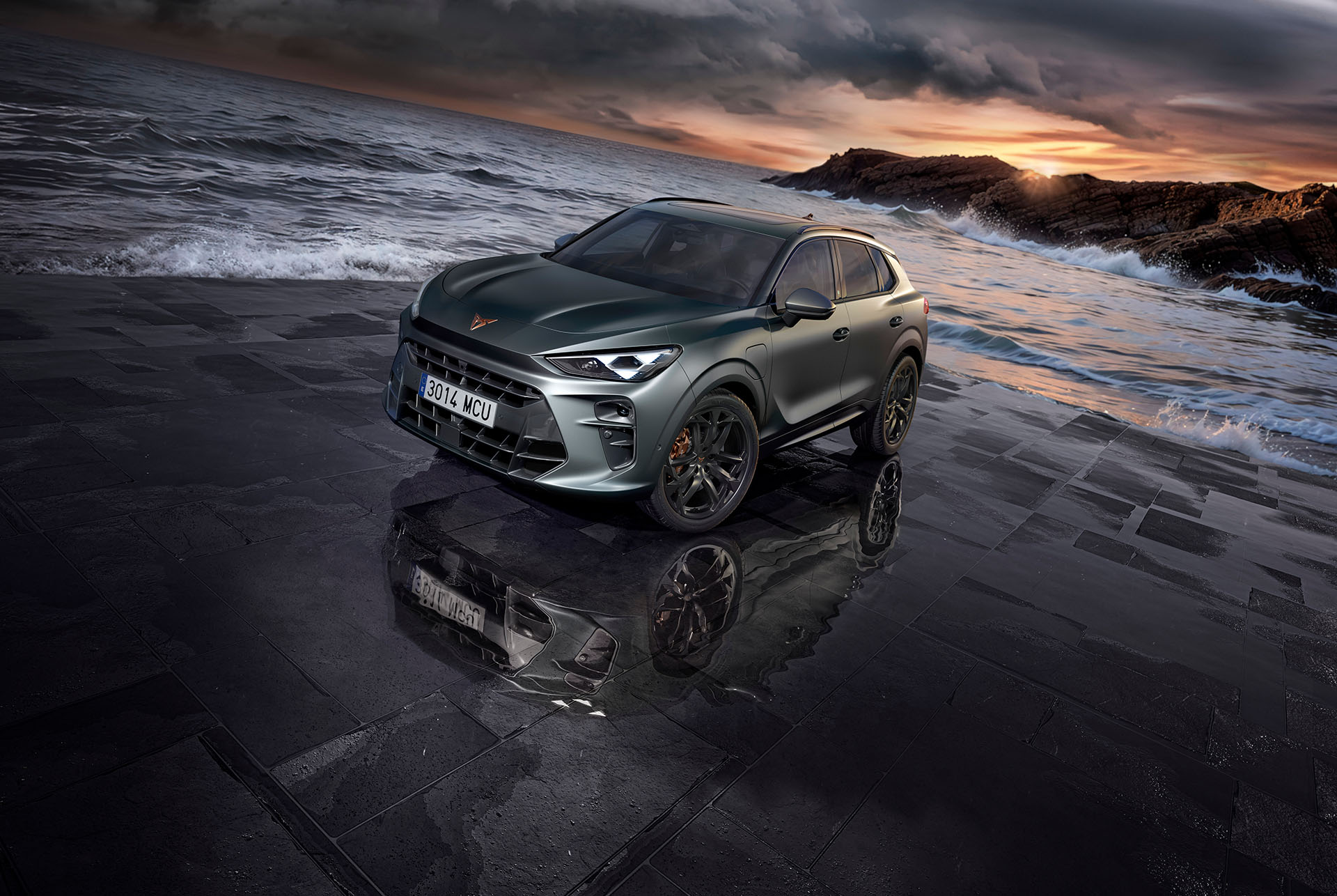 El nou SUV híbrid Cupra Terramar 2025 sobre un paviment mullat al costat de la mar, amb elegants fars, modernes llandes d'aliatge i un disseny frontal inspirat en un tauró.