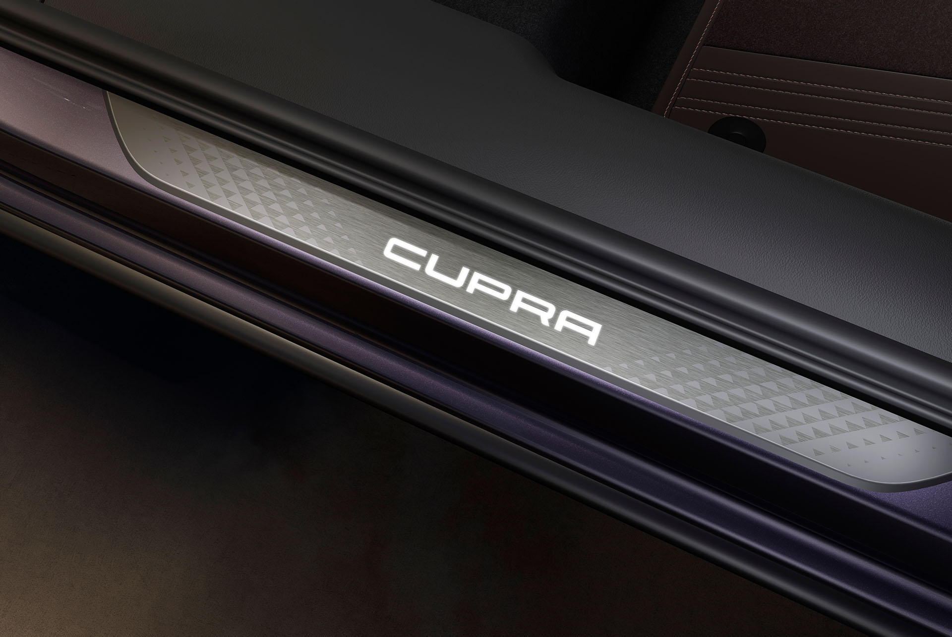Detall de l’actualització d’equipament: primer pla dels llindars de porta il·luminats a l’interior del Cupra Terramar VZ en color Dark Void.