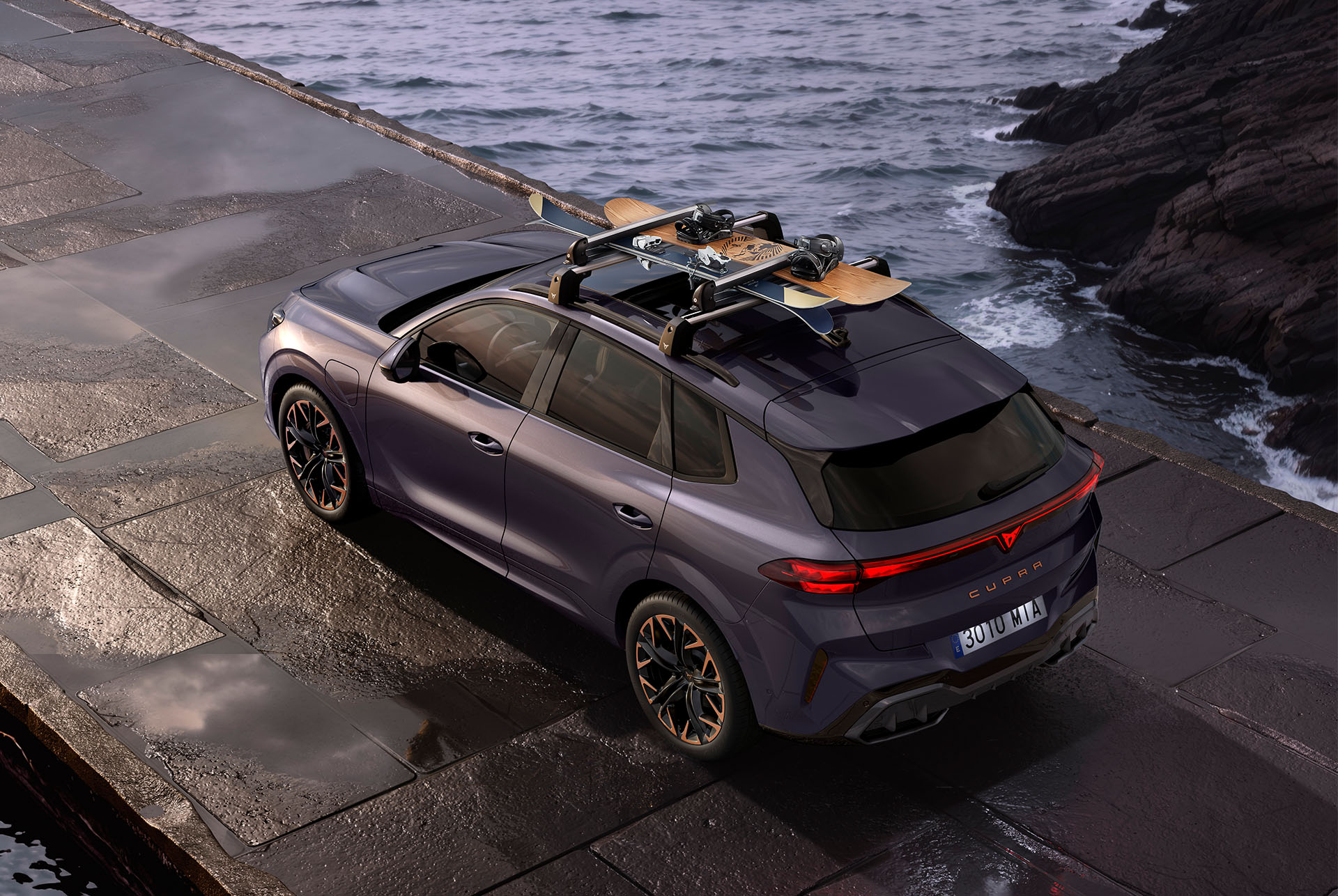 CUPRA Terramar amb portaesquís transportant esquís. El SUV està estacionat en una carretera costanera, preparant-se per a una aventura d'hivern, mostrant la versatilitat del vehicle i el sistema de portaesquís fàcil d'instal·lar.